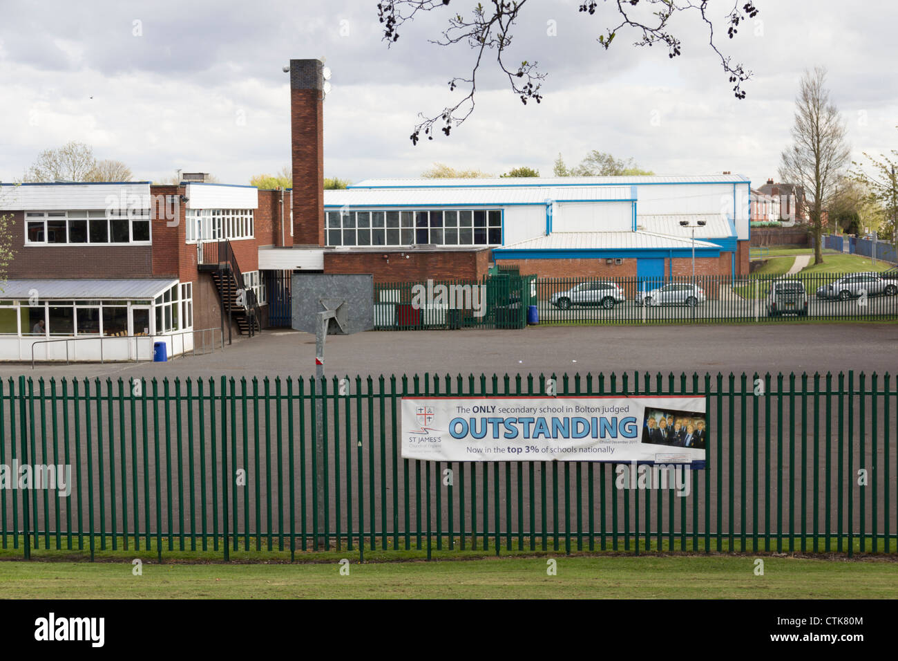 Außenseite des St. James Church Of England Mittelschule, Farnworth mit Banner verkünden ranking als "Herausragend" durch OFSTED Stockfoto