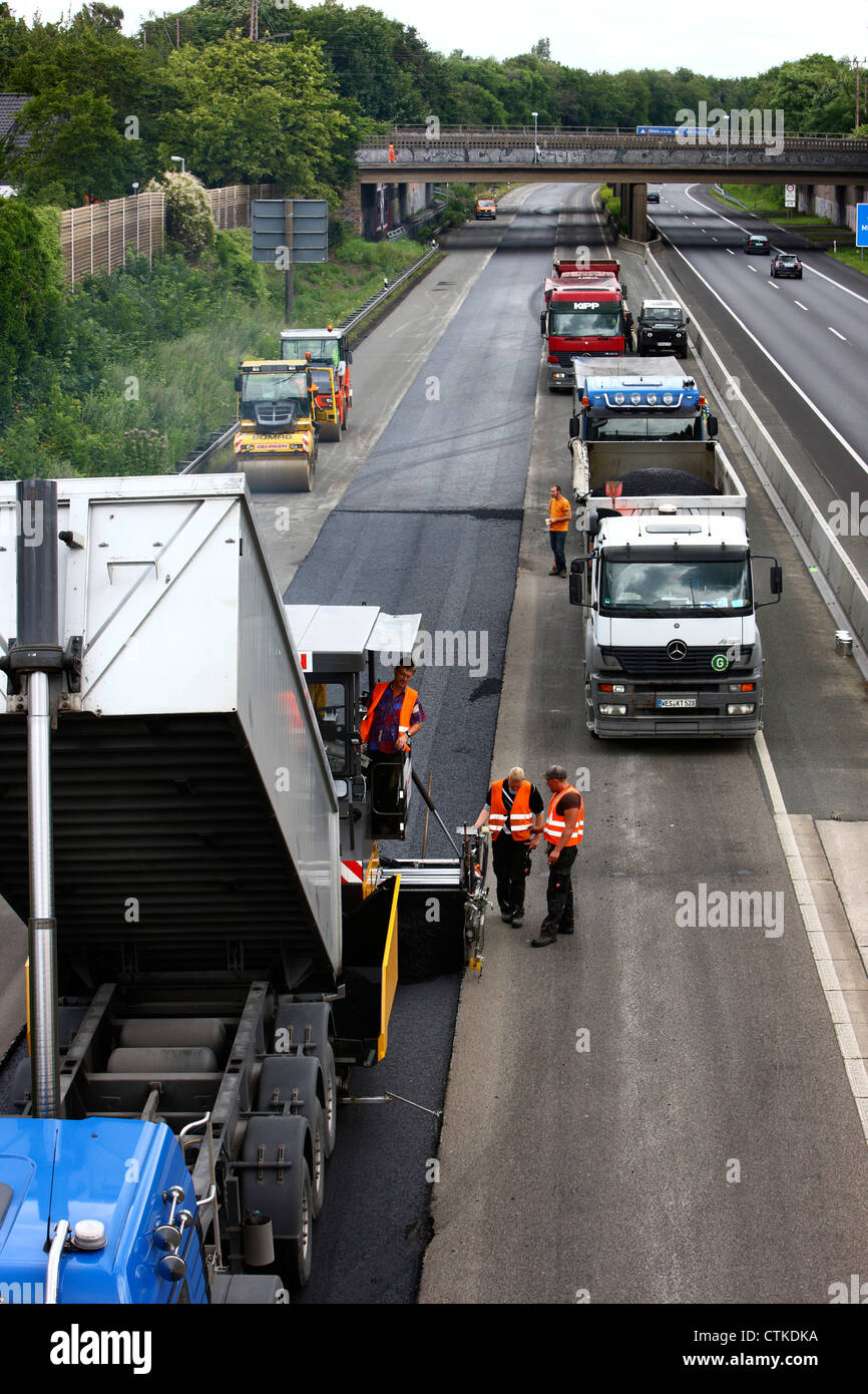 Autobahn, Autobahn A40, Installation einer neuen Asphaltdecke auf der Fahrbahn von Duisburg. Deutschland. Stockfoto