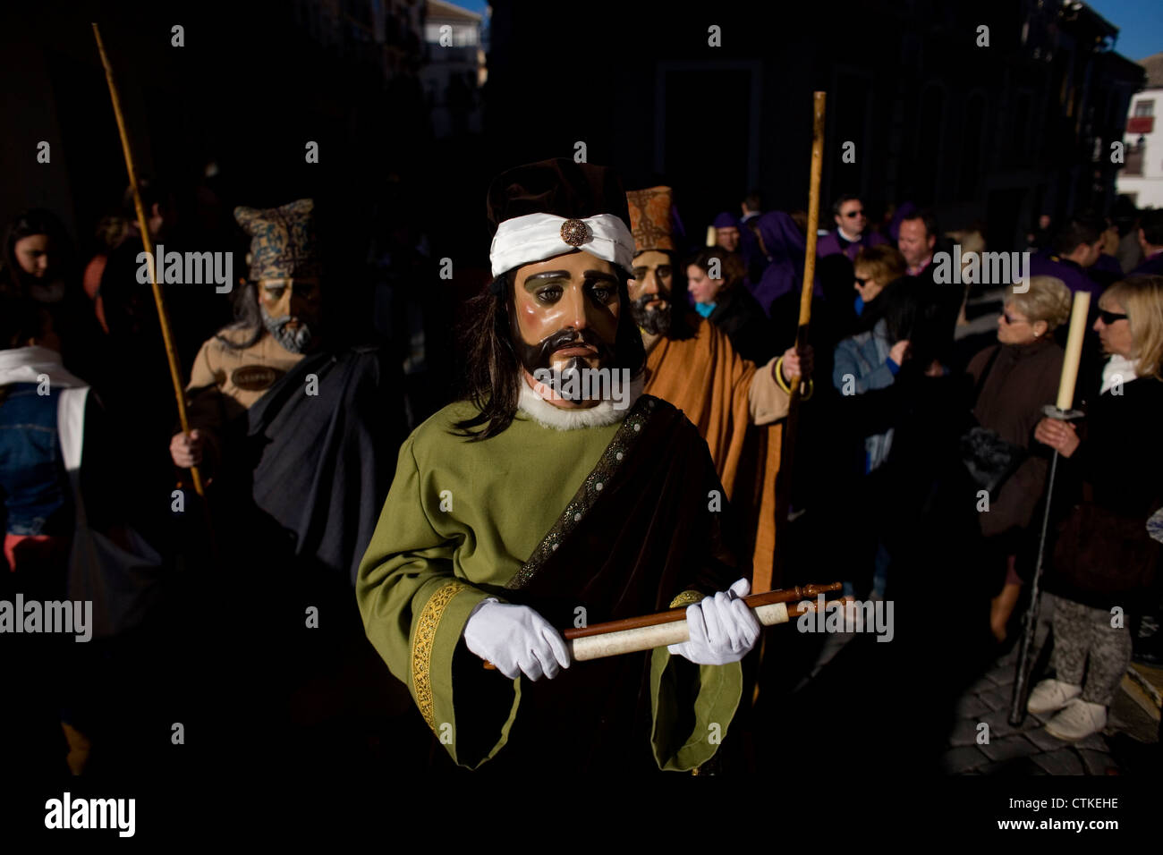Ein maskierter Mann gekleidet wie eine biblische Figur ein Pergament während einer Prozession der Karwoche in Puente Genil, Spanien hält Stockfoto