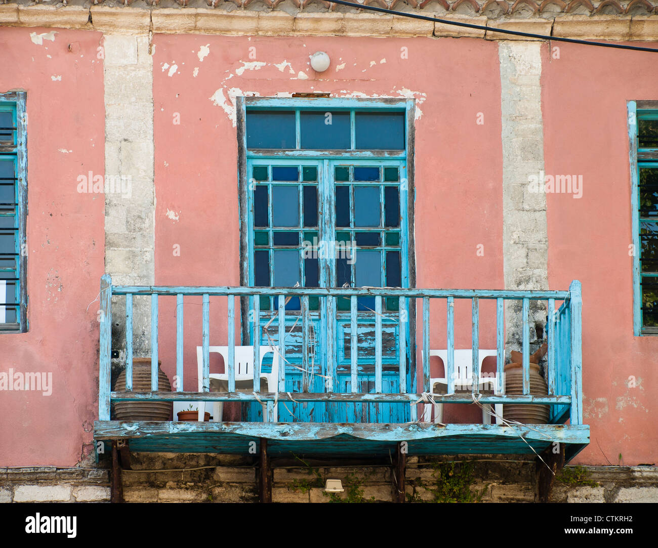 Müde Balkon mit Plastikstühlen im typisch griechischen blau Stockfoto