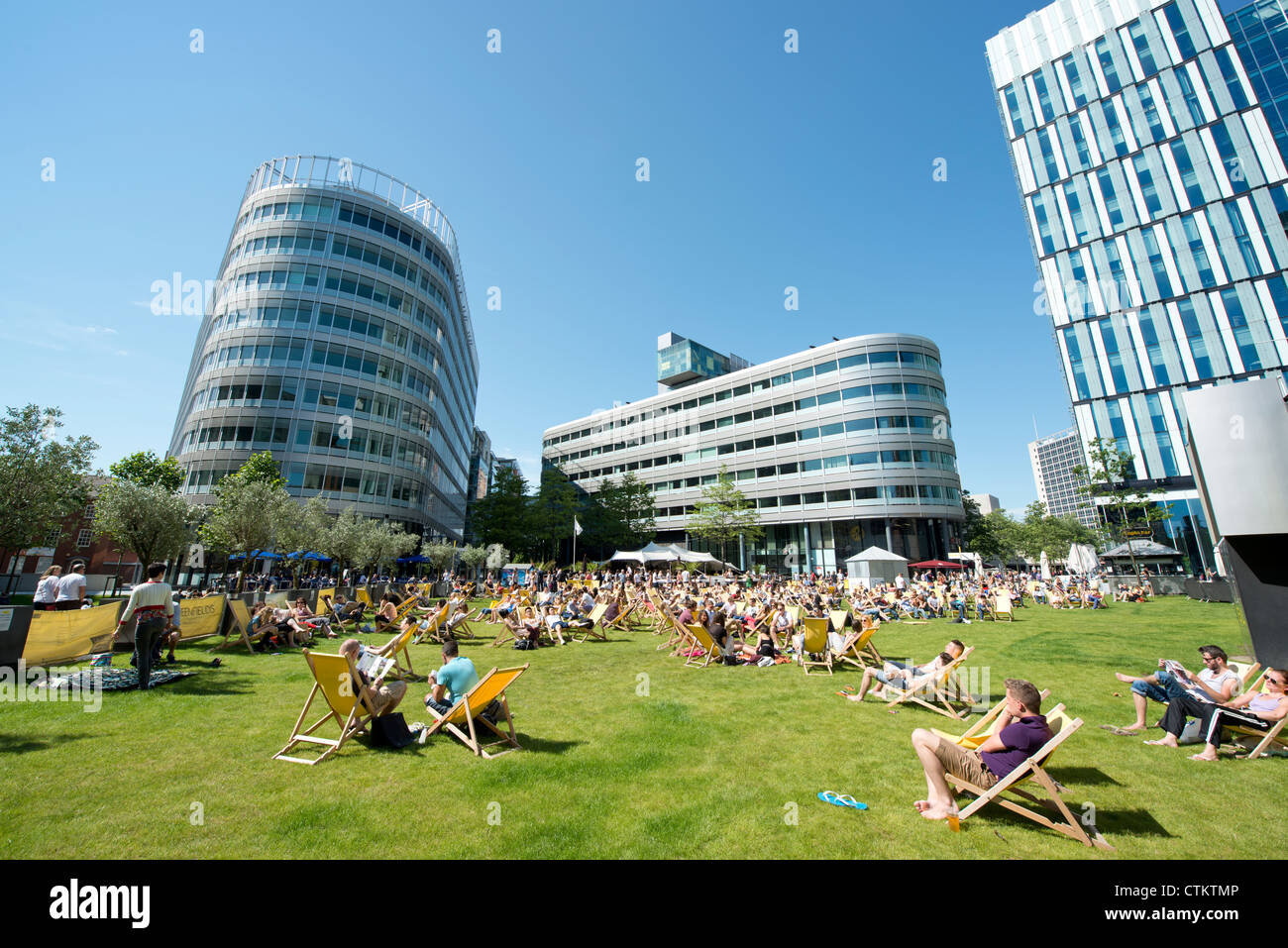 Menschen entspannen Sie an einem sonnigen Sommertag im Spinningfields von Manchester. Stockfoto