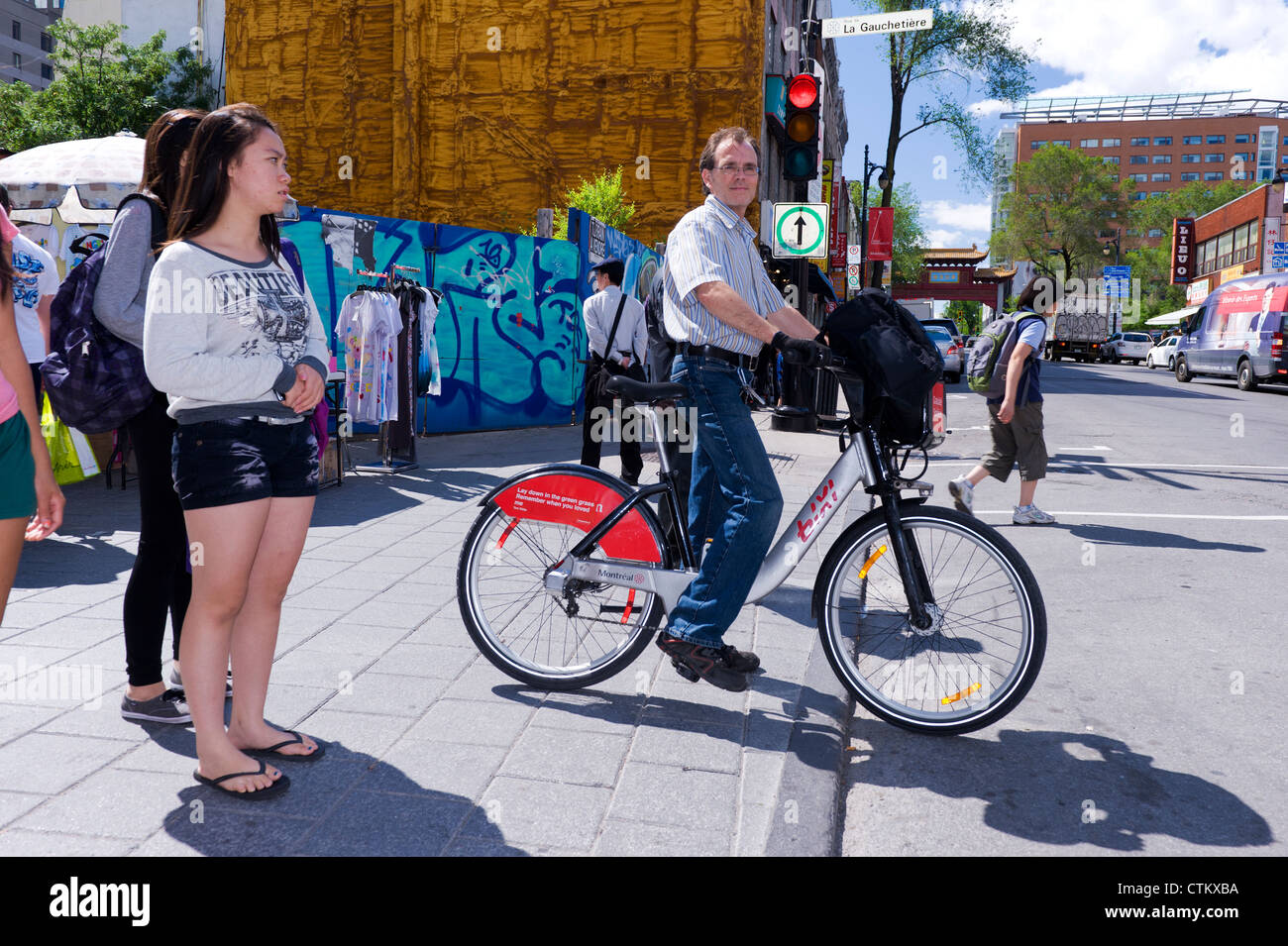 Mann die Straße überqueren, auf einem Leihfahrrad Bixi in Montreal, Québec, Kanada. Stockfoto