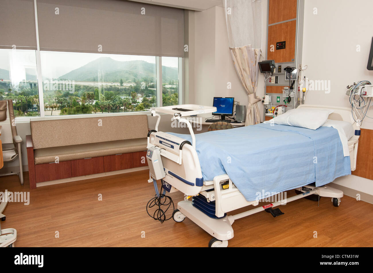 Ein großes modernes Krankenhauszimmer mit Blick auf die Stadt außerhalb. Stockfoto