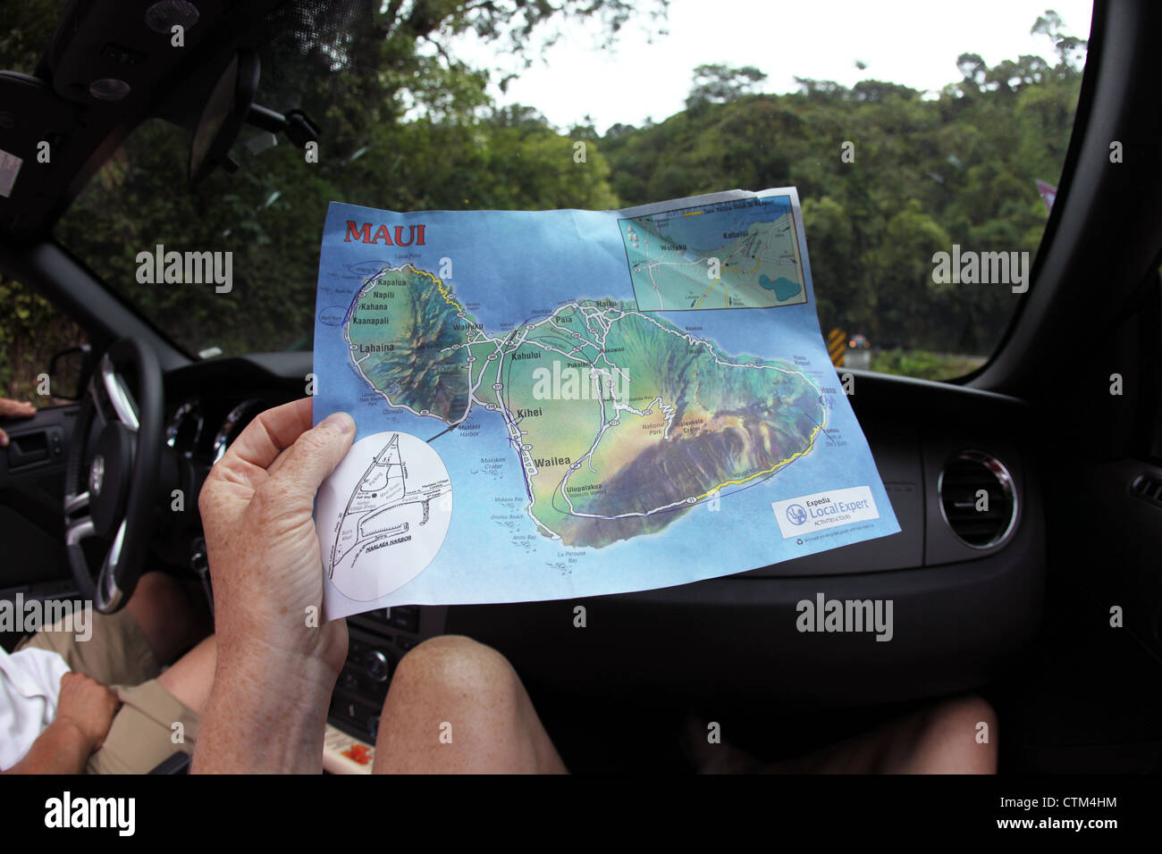 Eine Person im Besitz einer Karte von Maui seit langem Cabrio in einem Auto auf der Straße nach Hana. Stockfoto