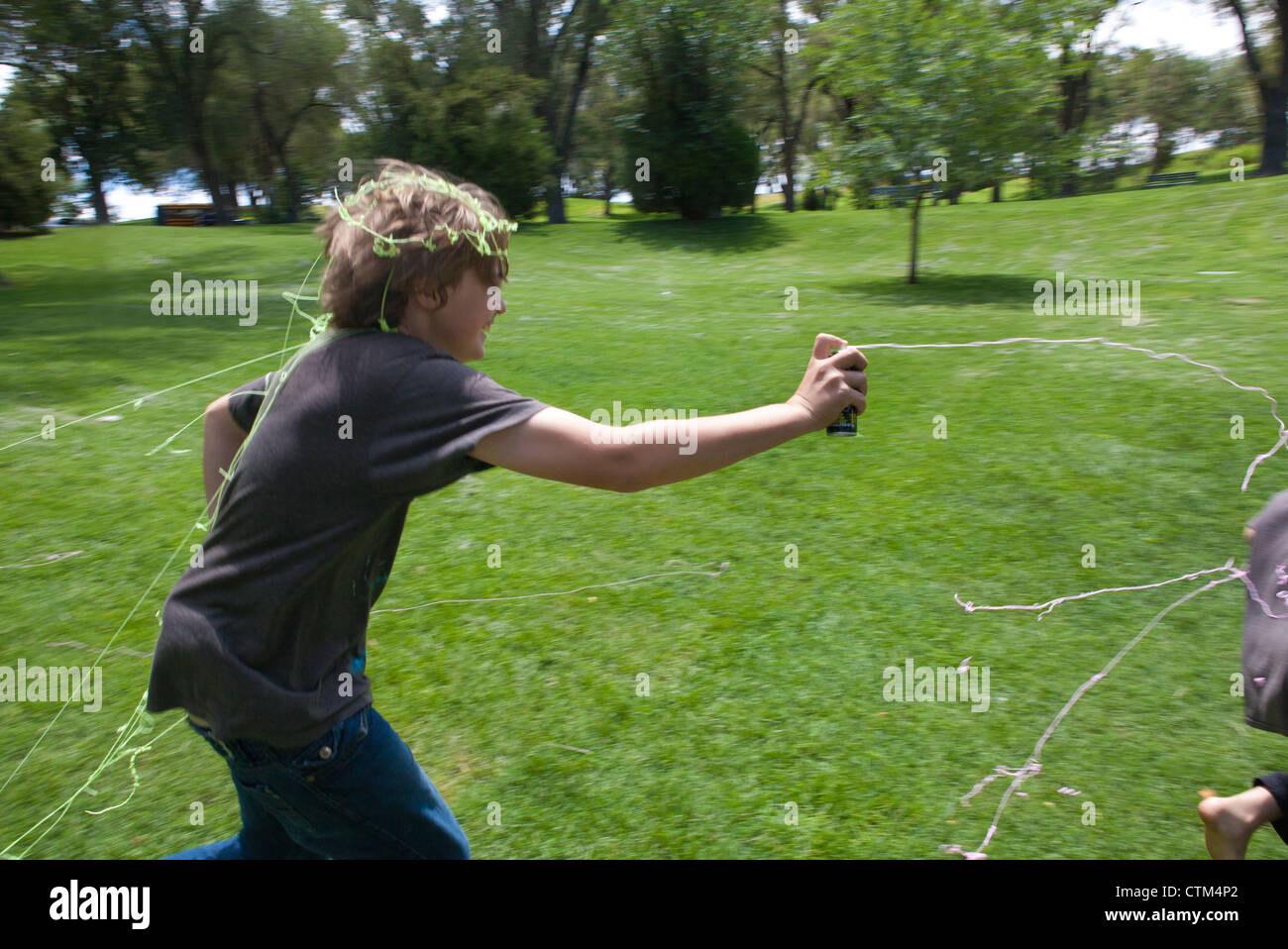 13 Jahre alte junge läuft in einem Park mit dummen String (liquid Latex Spray), beliebtes Spiel in Vereinigte Staaten. Stockfoto