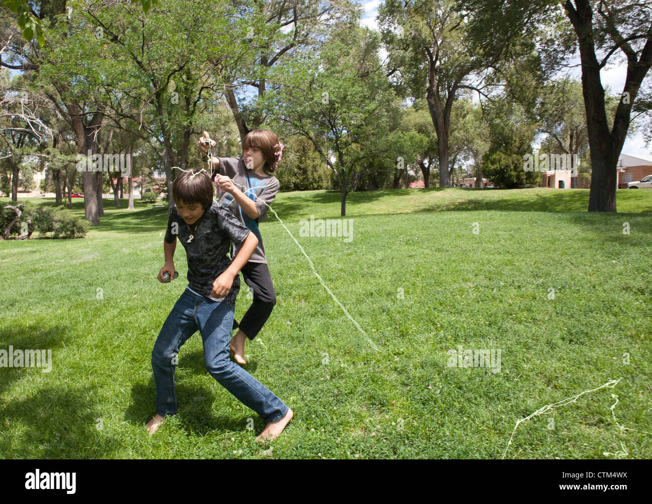 Jungen, die einander angreifen mit dummen String (flüssige Spray Latex) in einem Park, USA. Stockfoto
