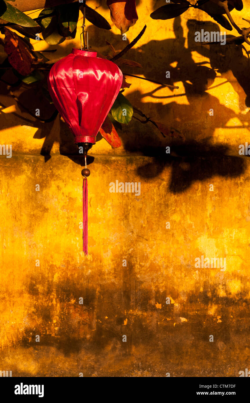 Roter Seide Laterne auf einer ockerfarbenen Mauer, am späten Nachmittag, Hoi An, Vietnam Stockfoto