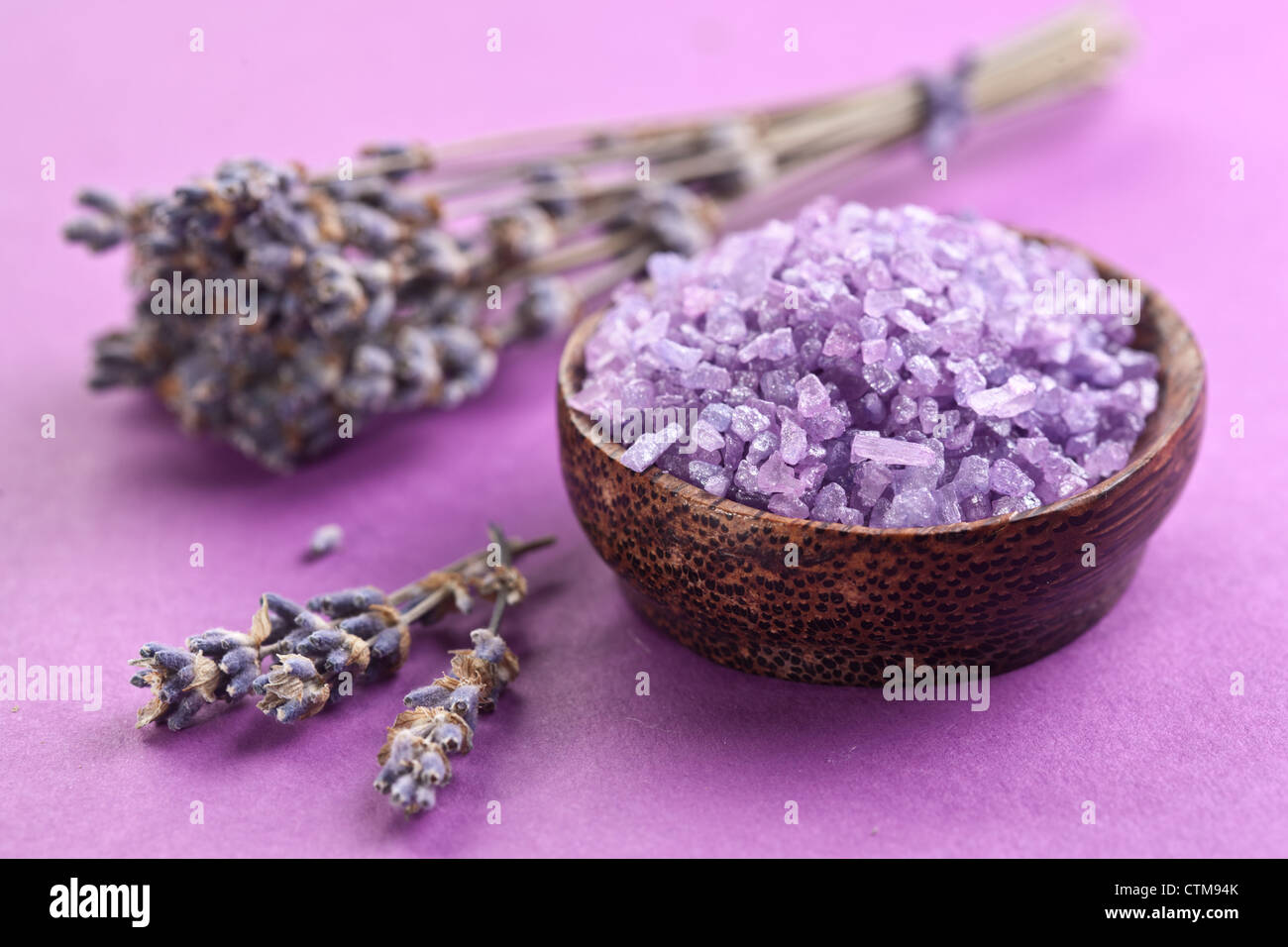 Meersalz und getrocknetem Lavendel auf violettem Hintergrund. Stockfoto