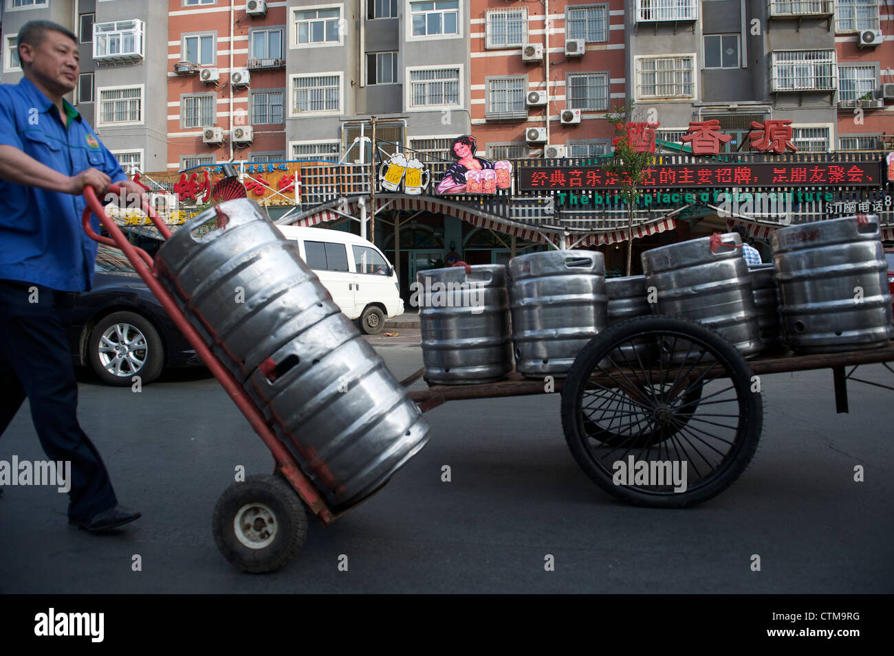 Ein Mann Rundles eine Schubkarre mit Fass Bier in Qingdao, Shandong, China. 2012 Stockfoto