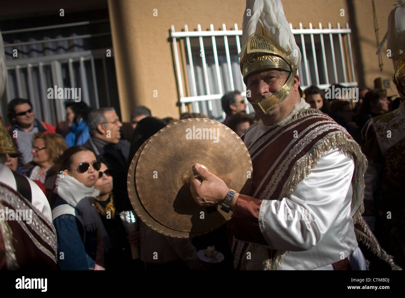 Ein Mann gekleidet wie ein römischer Legionär der Becken in einer Musikkapelle, während der Karwoche, Puente Genil, Andalusien, Spanien spielt Stockfoto