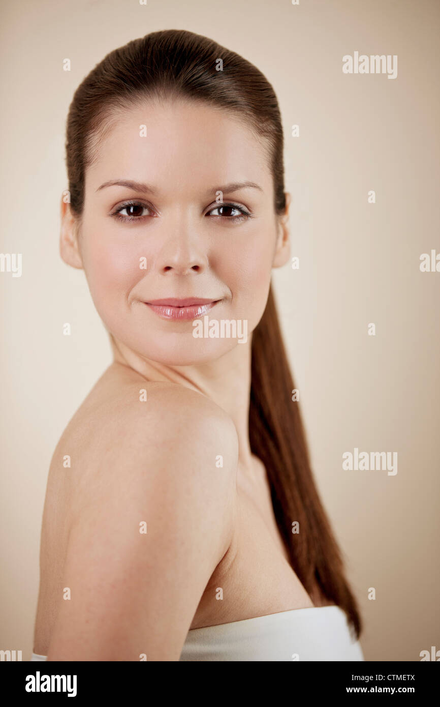 Eine junge Brünette Frau lächelnd an Kamera Stockfoto