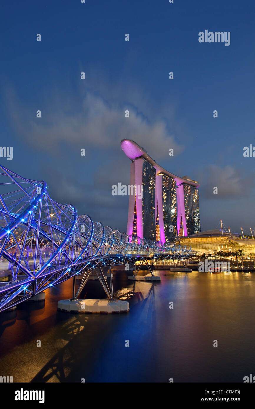 Helix-Brücke und die Marina bay Sands luxuriöse fünf-Sterne-Hotel in der Abenddämmerung in Marina Bay, Singapur Stockfoto