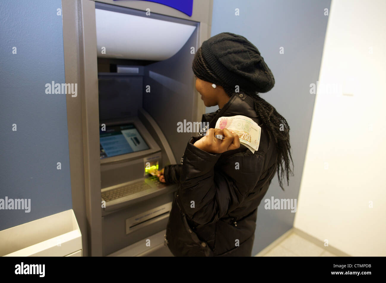 Eine junge Frau, die Zeichnung Geld aus Geldautomaten, Pietermaritzburg, KwaZulu-Natal, Südafrika Stockfoto
