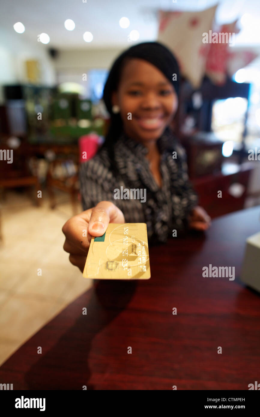 Eine junge Frau, die Zahlung mit ihrer Kreditkarte, Pietermaritzburg, KwaZulu-Natal, Südafrika Stockfoto