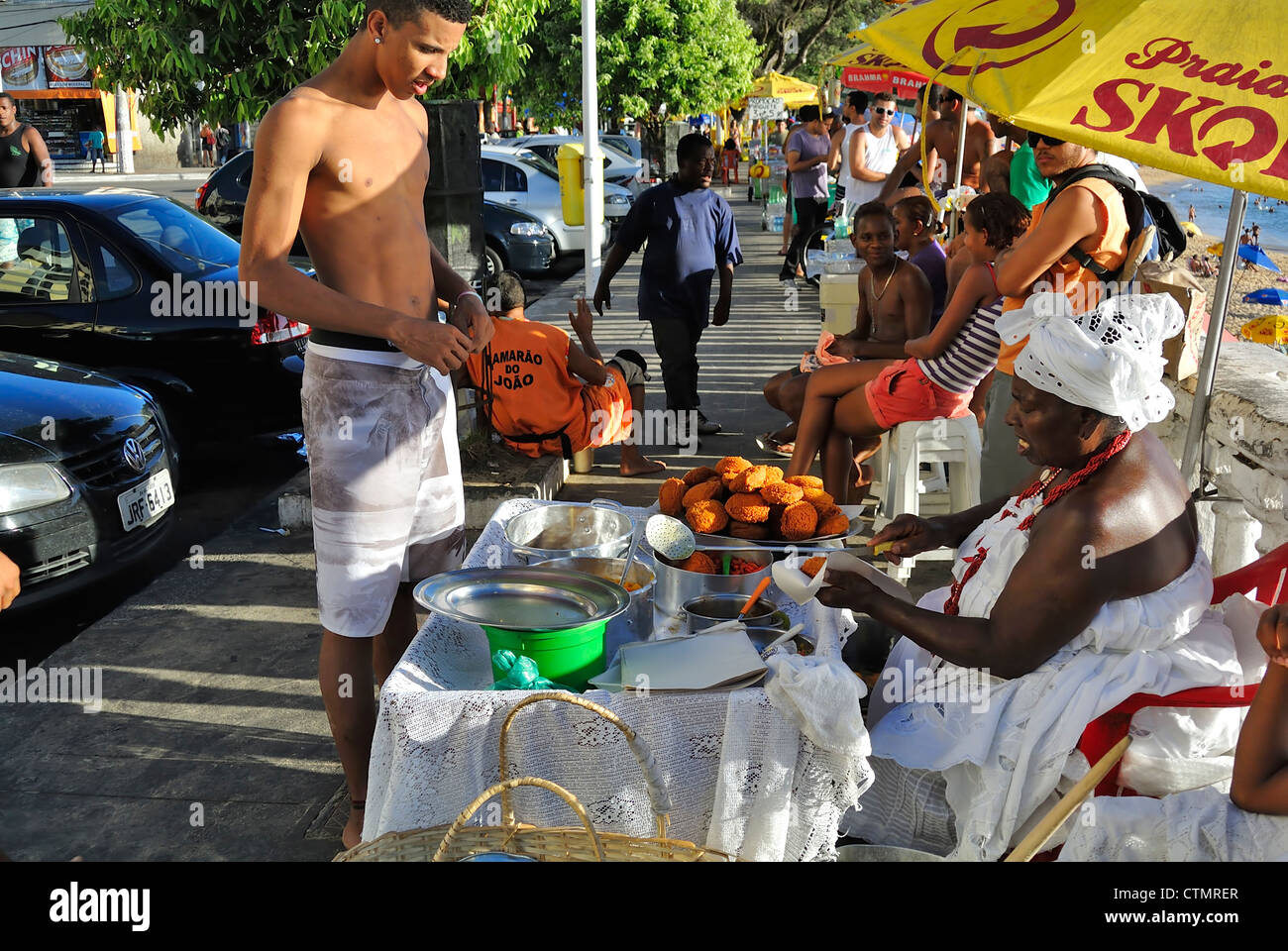 Salvador, Brasilien, ein lokaler Mann kaufen Acaraje Wissen als lokale Seele Nahrung in der Straße. Stockfoto