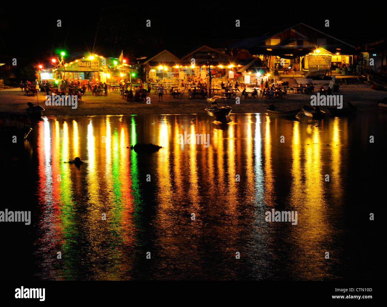 Die Wirkung der Lichtreflexion auf dem Wasser, das von Restaurants in der Nähe des Strandes kommt. Stockfoto