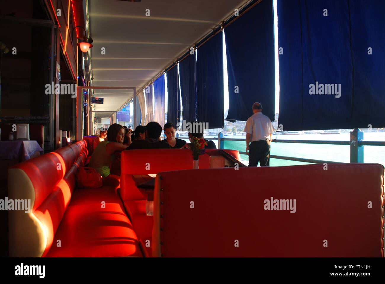 Dinner unter Galata-Brücke in Istanbul, mit Blinds nach unten um zu blockieren, die Sonne. Bild von: Adam Alexander/Alamy Stockfoto