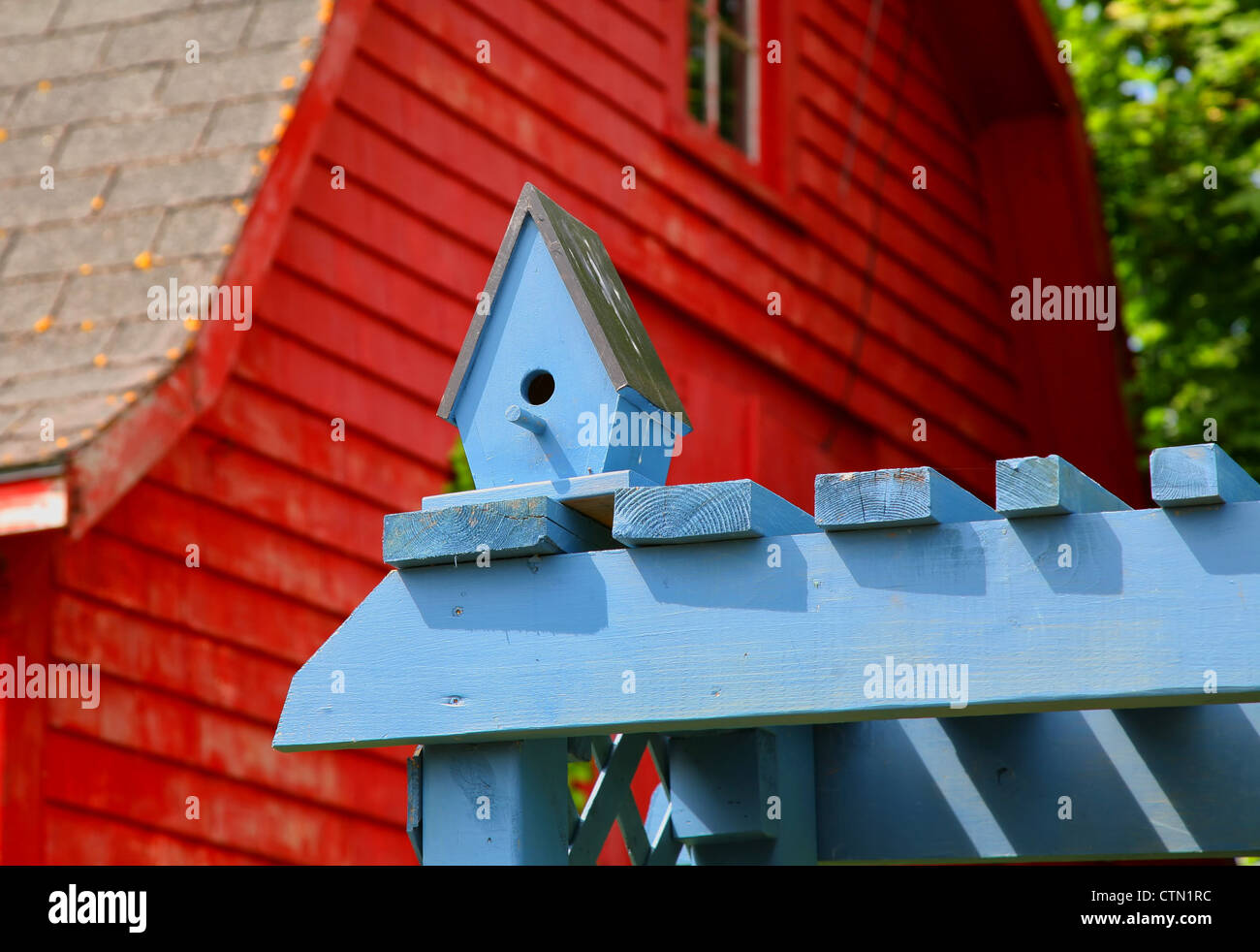 Eine hölzerne Vogelhäuschen auf eine blaue Laube in einem Hinterhof-Garten. Stockfoto