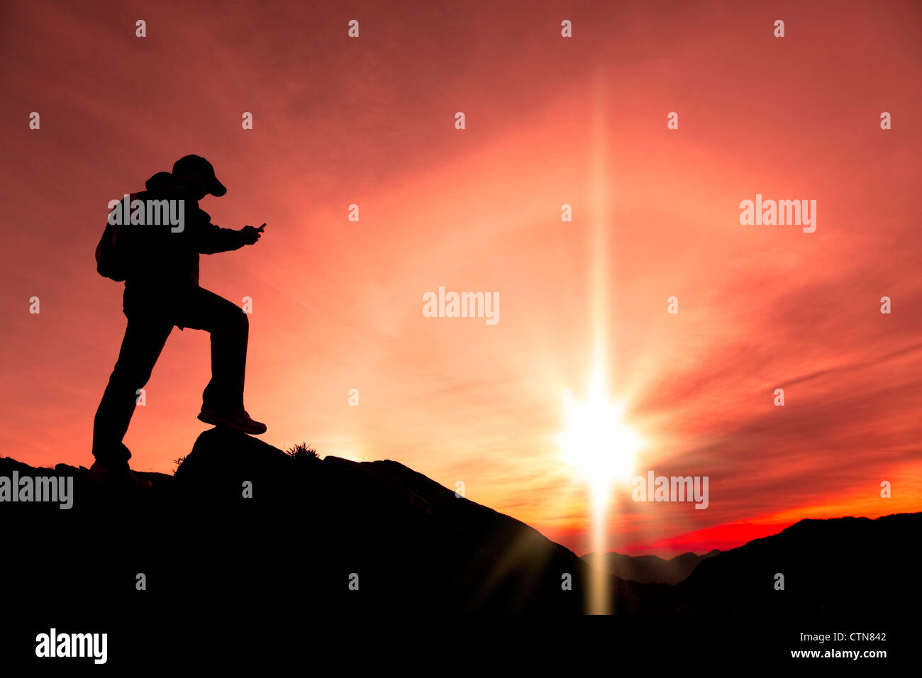 junger Mann mit Smartphone auf Berg Stockfoto