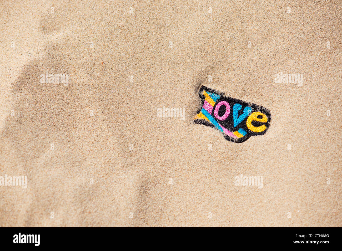Bunte Stickereien Aufbügeln Liebe Patch im Sand am Strand Stockfoto