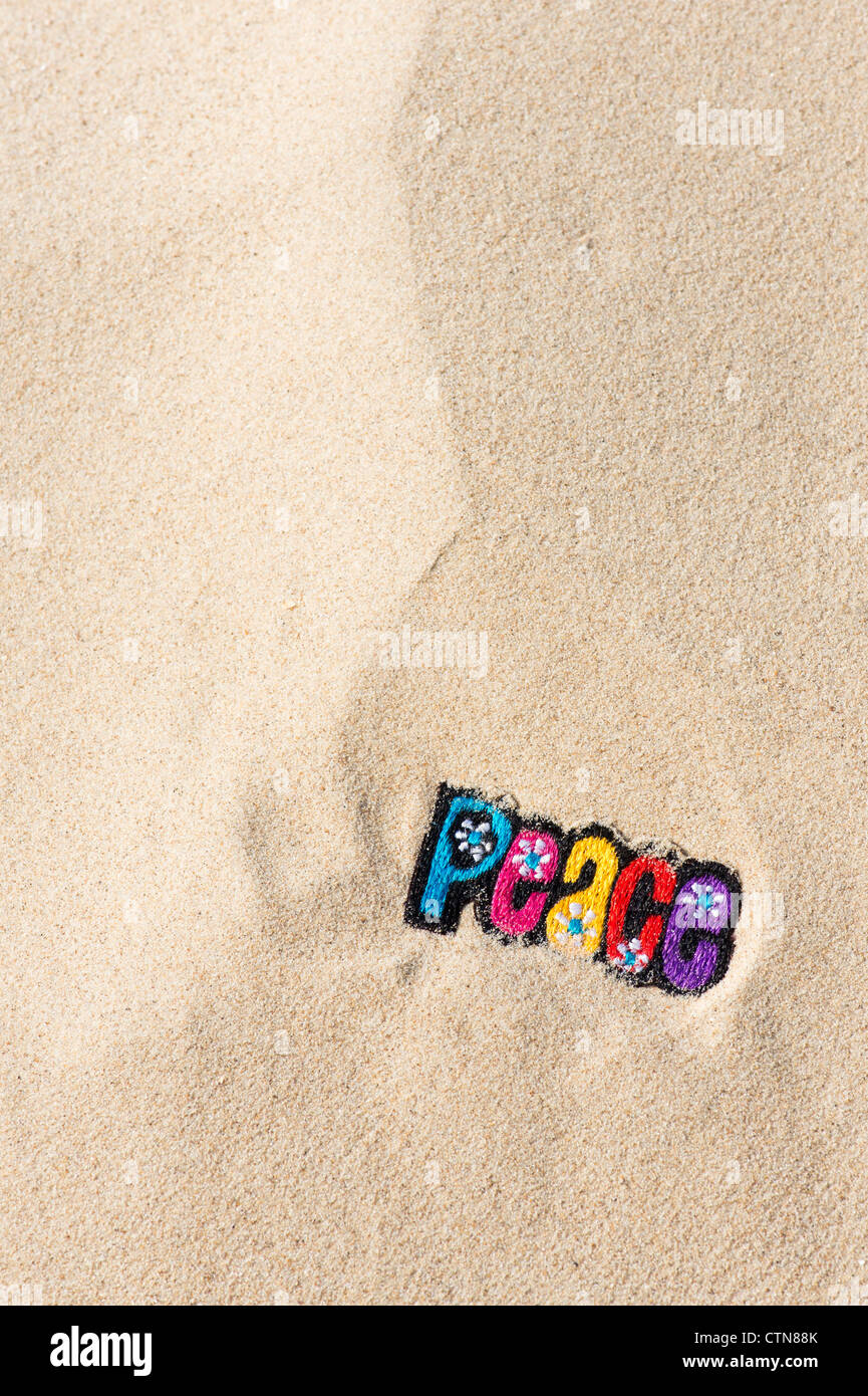 Bunte Stickereien Bügeln auf Frieden Patch im Sand am Strand Stockfoto