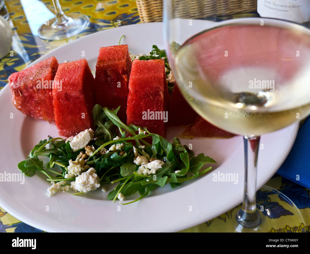 Wassermelone und Roquefort-Salat mit Glas Sauvignon Blanc Wein Stockfoto