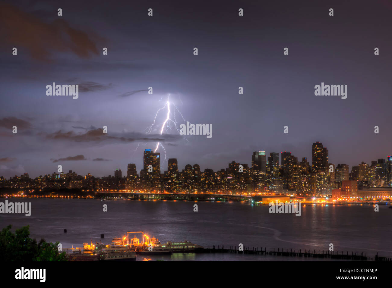 Blitze erleuchten den Nachthimmel über die upper West Side Skyline während eines Gewitters Sommer in New York City. Stockfoto