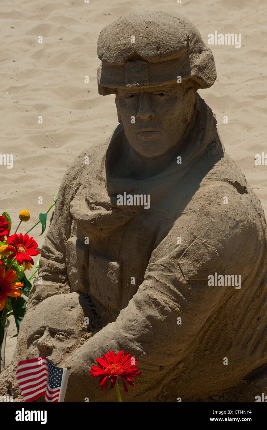 US Marine hergestellt aus Sand, hält einen kritisch Verwundeten Soldat am Arlington West Denkmal. East Beach, Kalifornien Stockfoto