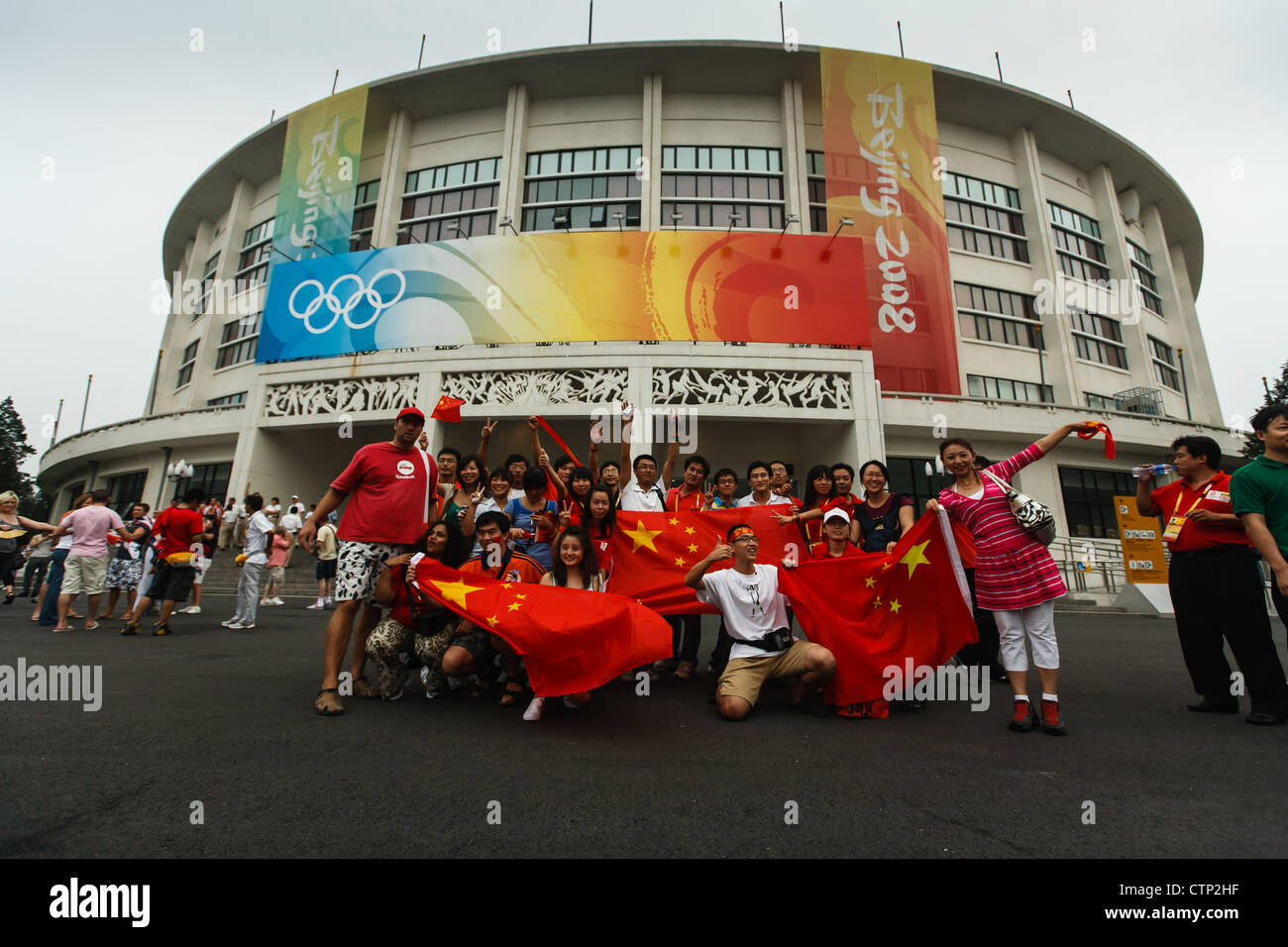 Peking, China - 24 2008 August: Jubelnde Fans der olympischen Pose mit chinesischen Fahnen außerhalb der Arbeitnehmer Gymnasium nach Boxen Finale Stockfoto