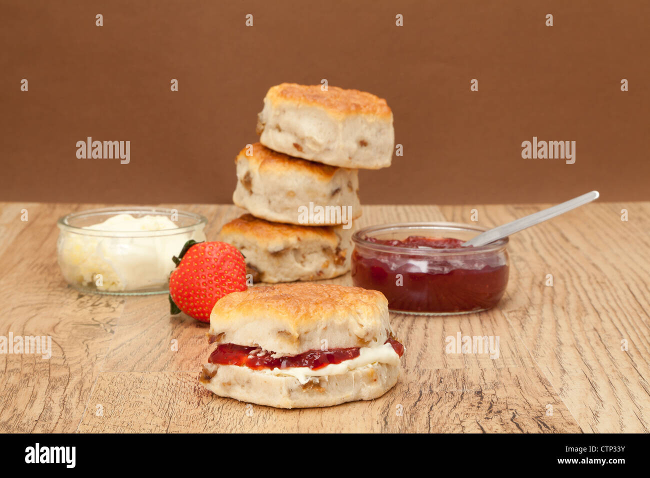 Lecker gebackene frisch Scones mit Clotted Cream und Erdbeermarmelade - Studio mit einem einfarbigen Hintergrund gedreht Stockfoto