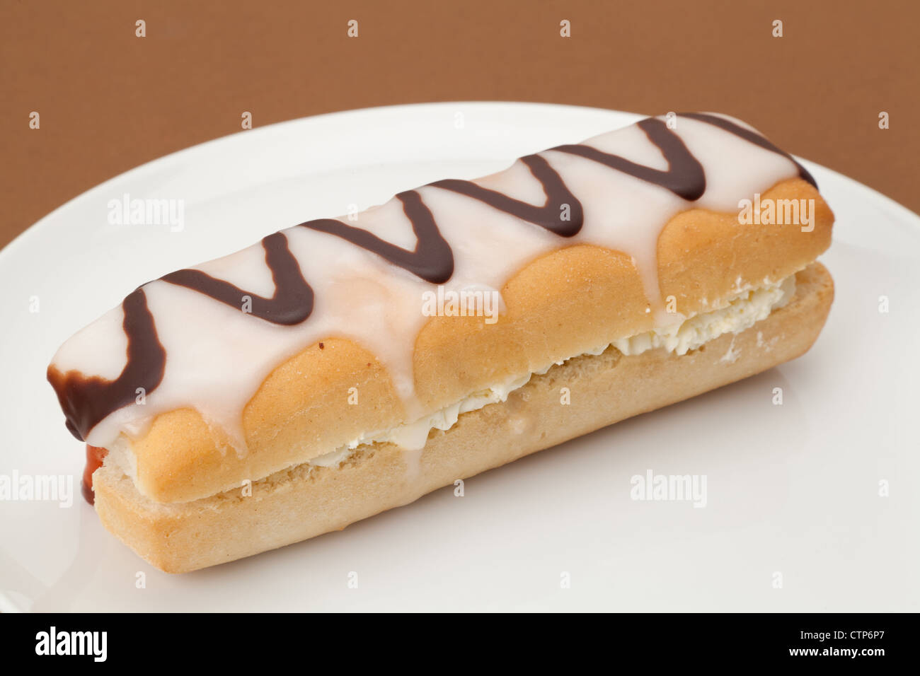 Frische Sahne Donut, serviert auf einem weißen Teller - Studio gedreht mit einem einfarbigen Hintergrund und geringe Schärfentiefe Stockfoto