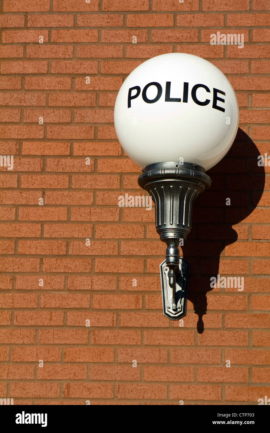 Alten altmodische Vintage Polizei Zeichen auf einem Globus Licht hängt an eine Mauer außerhalb einer Retro-gestaltete Stadt-Polizei-Station. Stockfoto