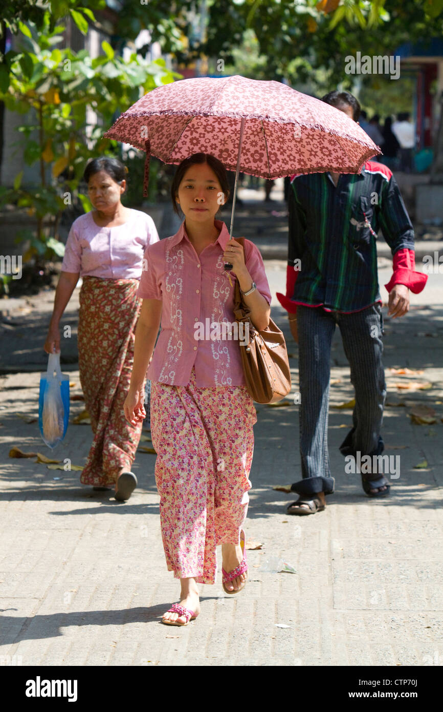 Burmesische Frau zu Fuß im Schatten eines Sonnenschirms in Yangon (Rangoon), Myanmar (Burma). Stockfoto