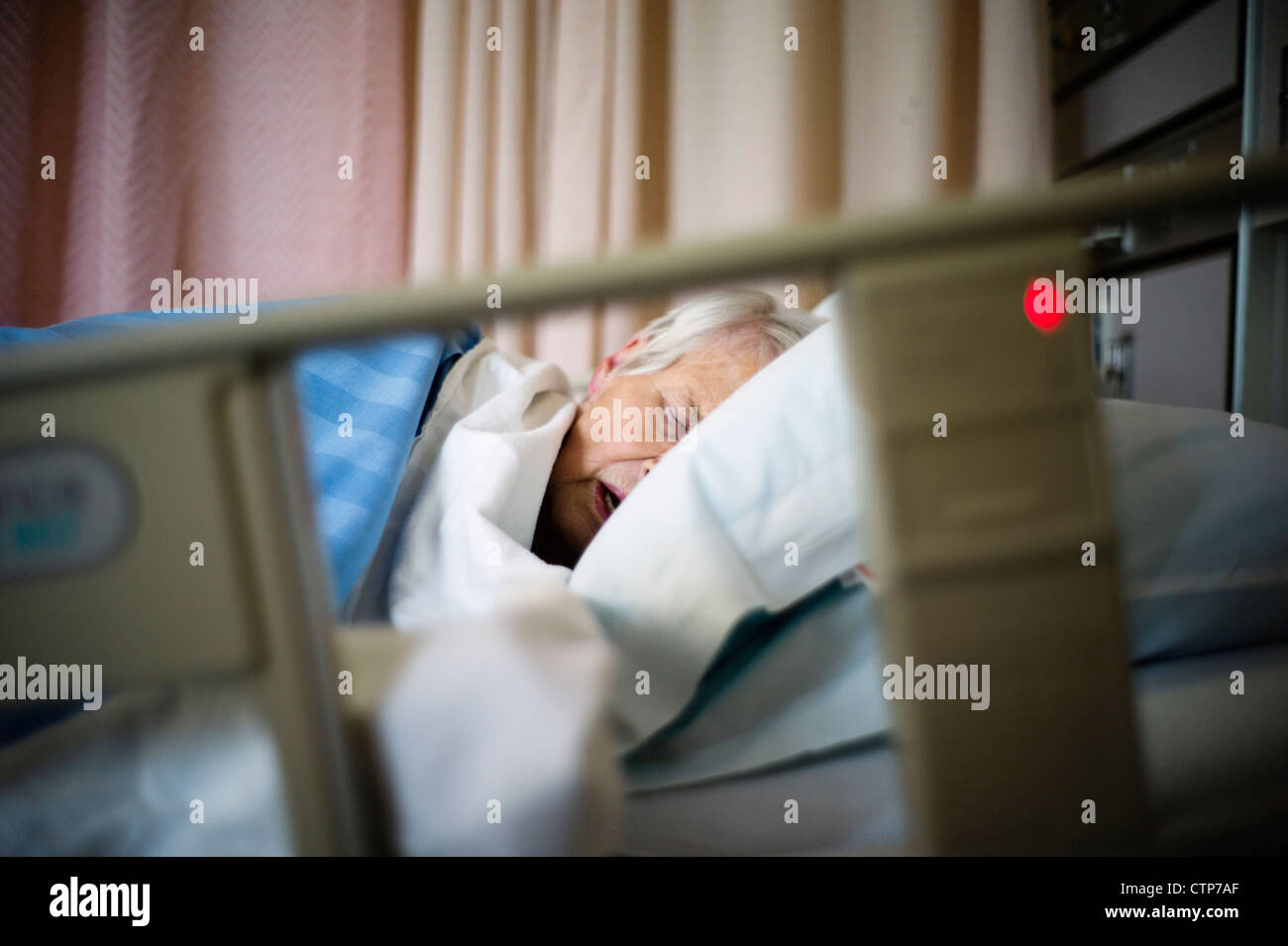 Alte Frau schläft in einem Krankenhausbett. Stockfoto