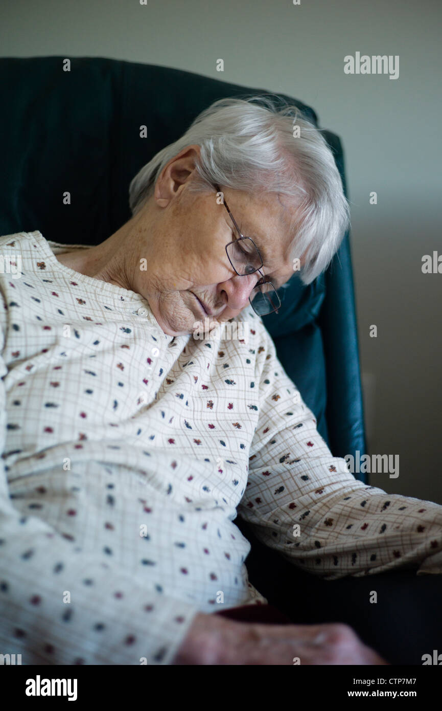 Alte Frau brach über schlafend im Sessel Stockfoto