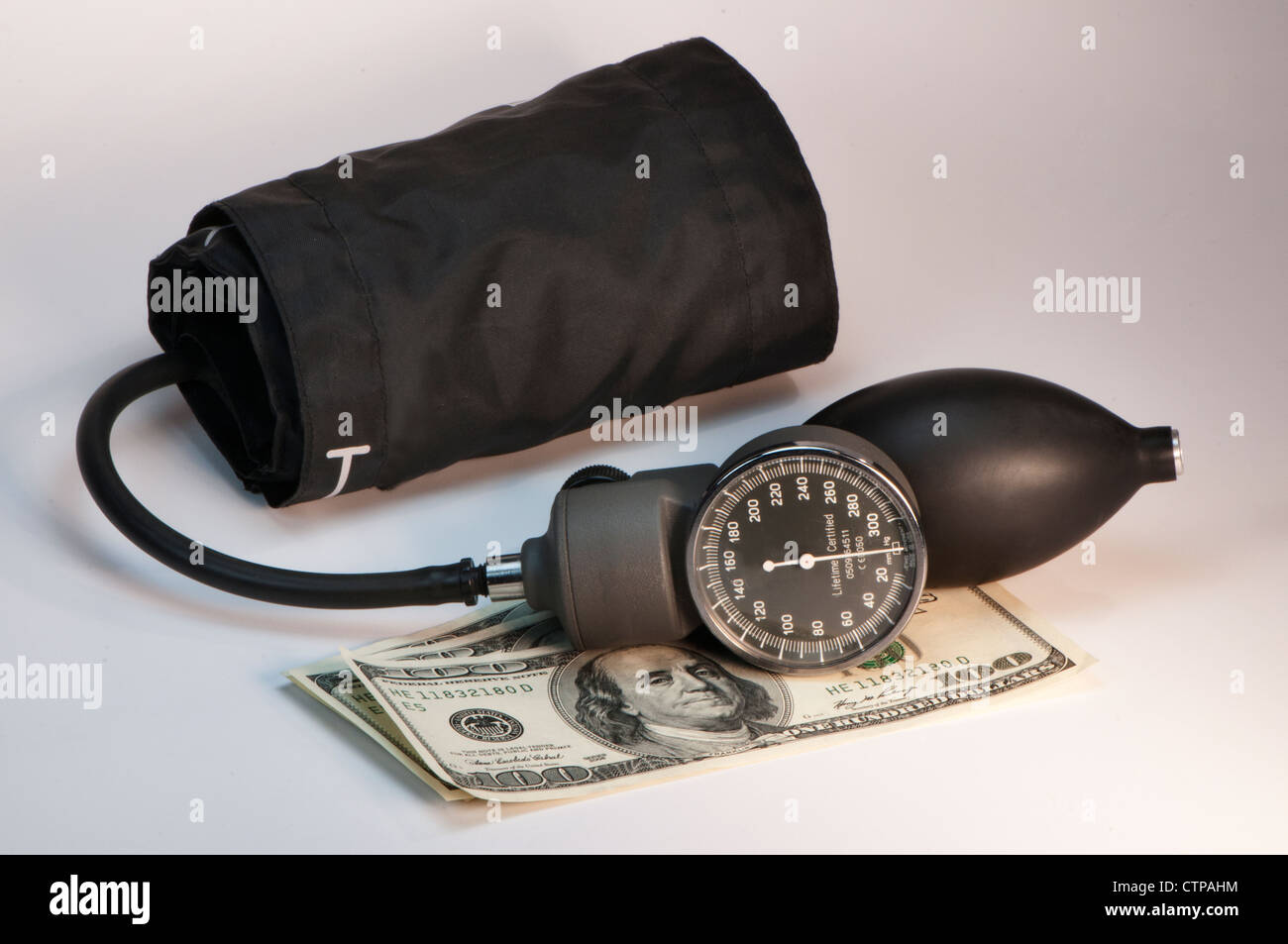 Blutdruckmanschette und hundert-Dollar-Scheine Stockfoto