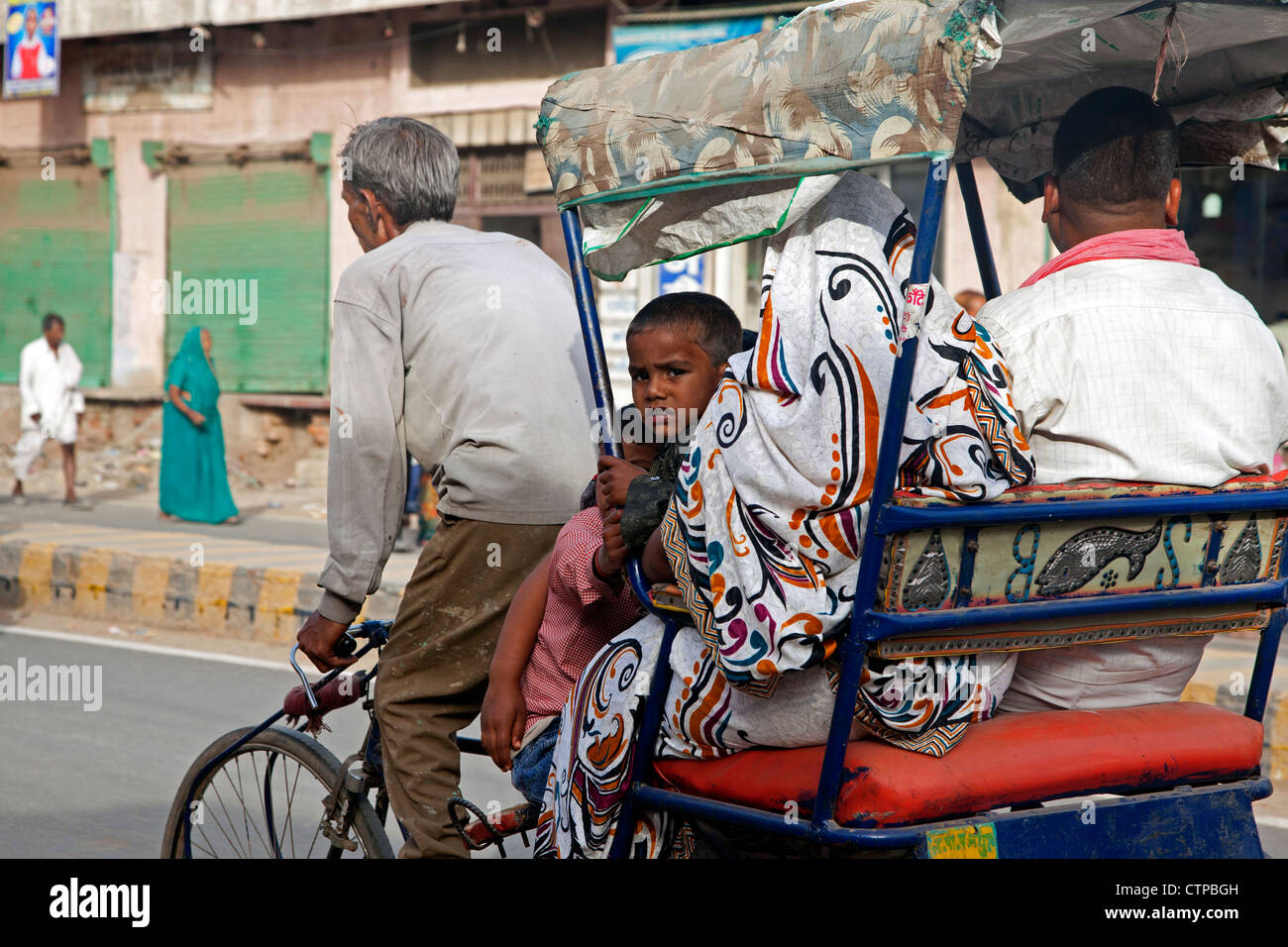 Rikscha-Zyklus mit alten Treiber Transport Familie als Stadtverkehr in Mathura, Uttar Pradesh, Indien Stockfoto