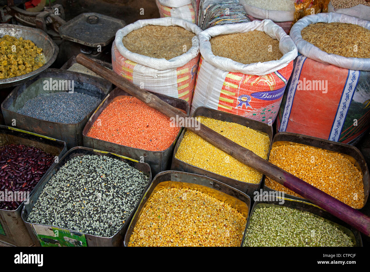 Bunte Lebensmittelzutaten wie Mais, Bohnen, Reis und Gewürze in Säcken und Dosen am Markt in Agra, Uttar Pradesh, Indien Stockfoto