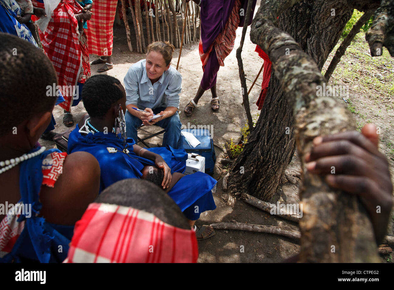Ein Freiwilliger aus Flying Medical Service untersucht Massai-Frauen und Kinder in einem abgelegenen Teil des nördlichen Tansania, Afrika. Stockfoto