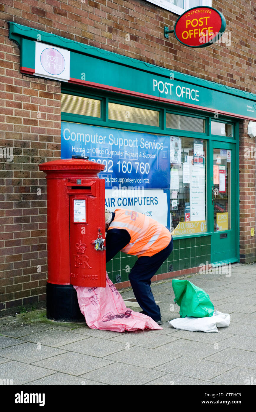 Postbote leeren Briefkasten außerhalb Postamt Stockfoto