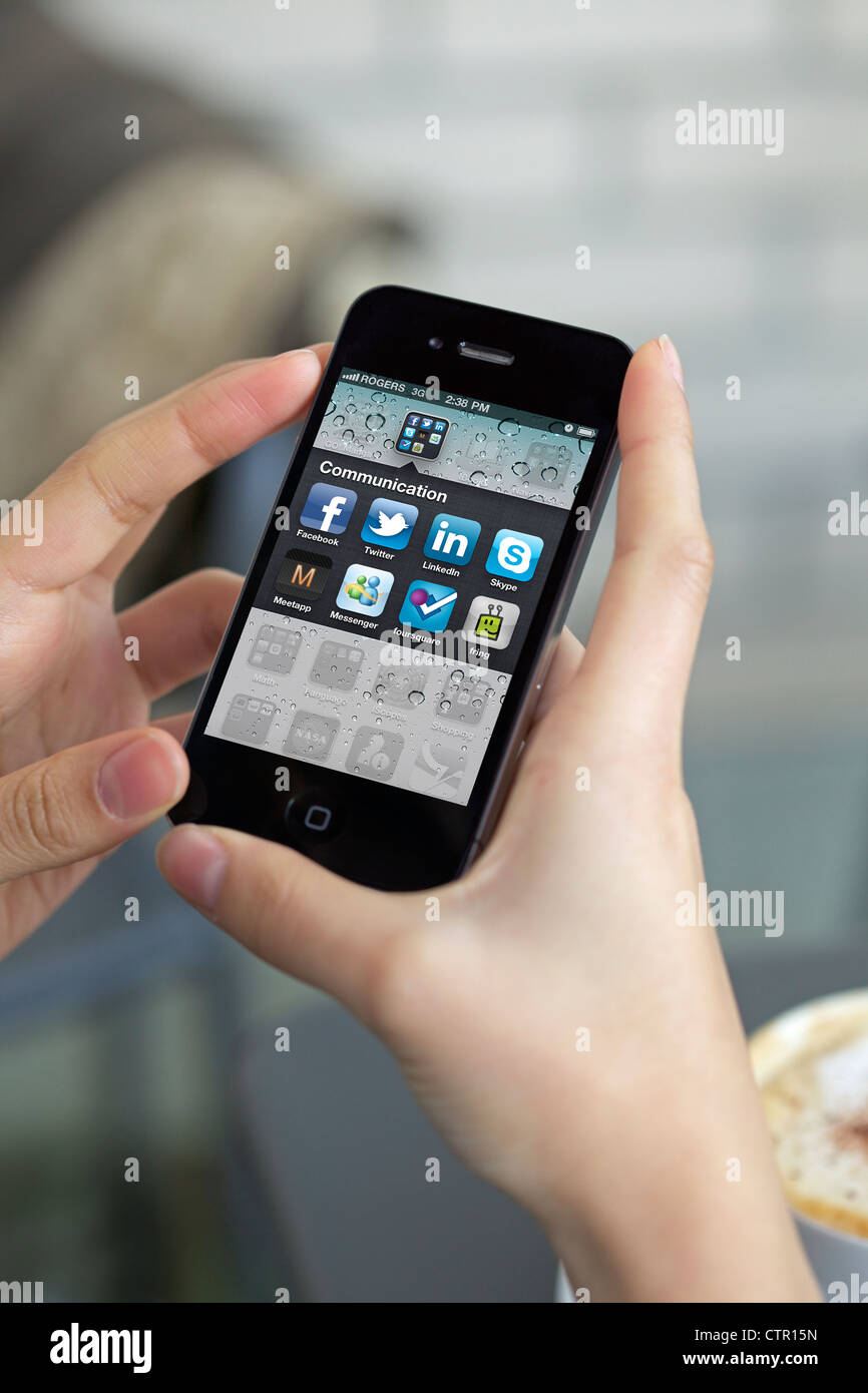Nahaufnahme Bild von einer Frau Hand hält ein iPhone 4 mit dem neuen iPhone (Retina Display/300 DPI) Anwendungsbildschirm Stockfoto