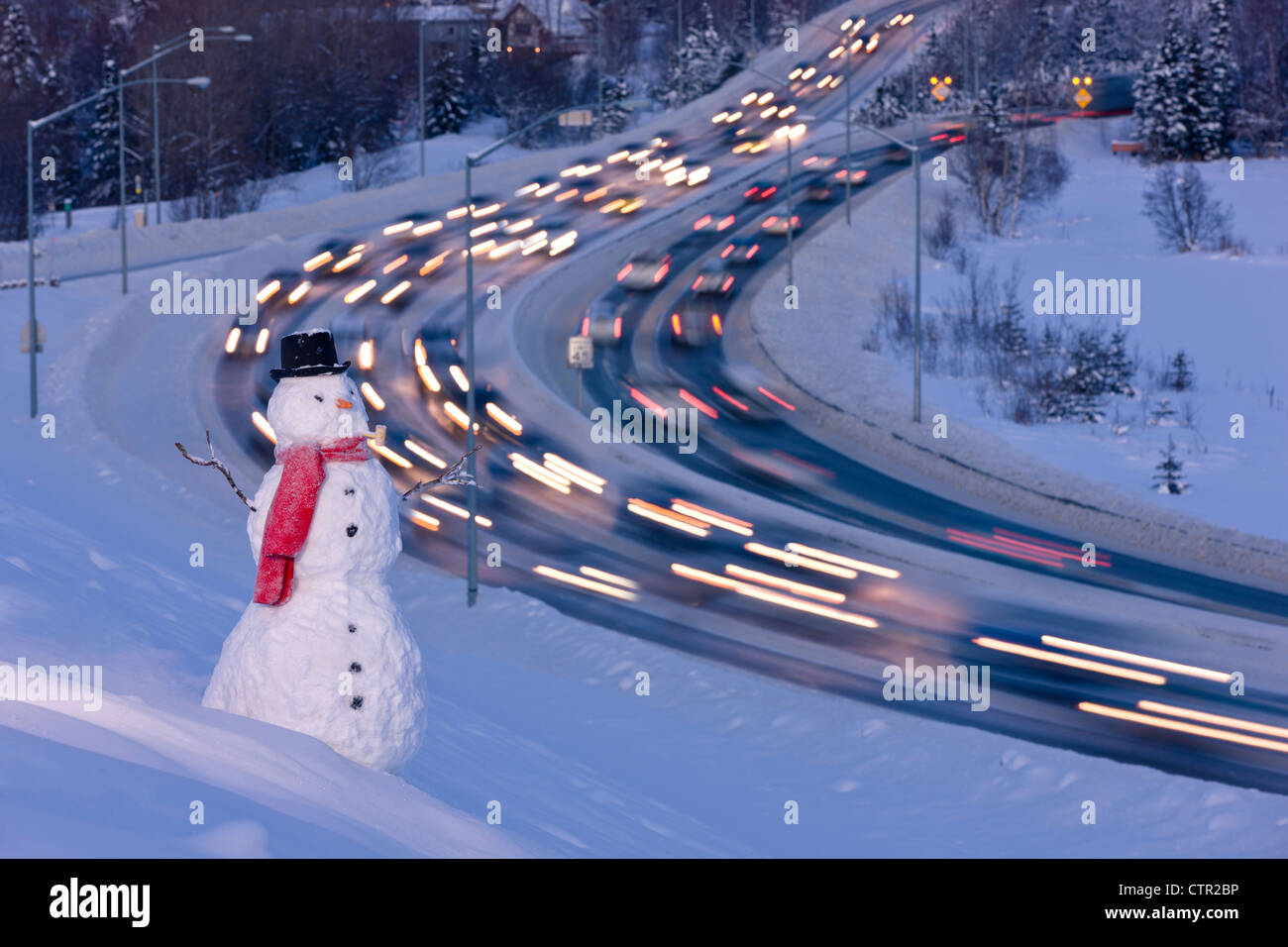 Blick auf Verkehr nahe der Innenstadt von Anchorage mit einem Schneemann im Vordergrund, Yunan Alaska Winter. Digital erweitert Stockfoto