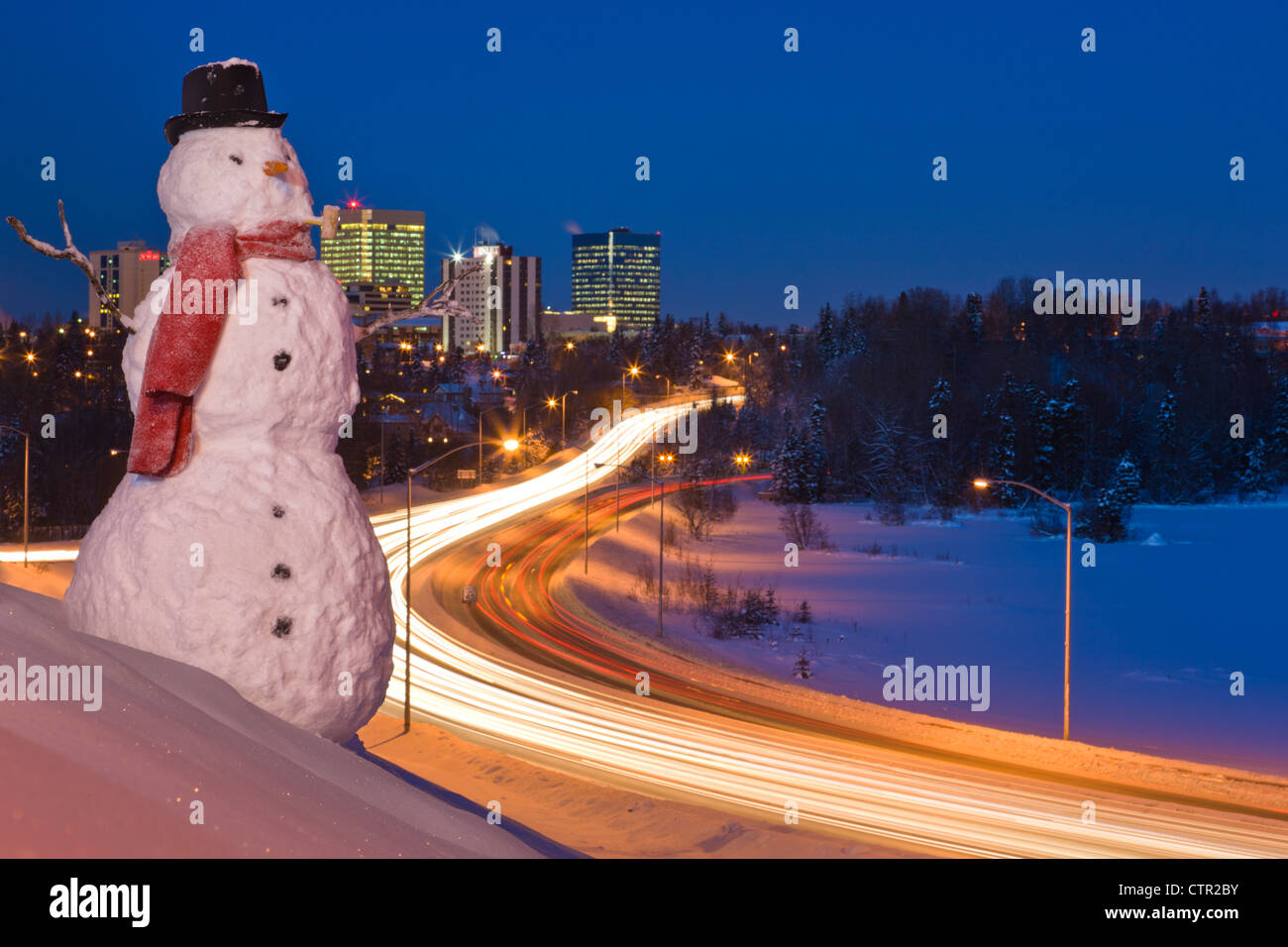 Blick auf den Verkehr und die Innenstadt von Anchorage mit einem Schneemann im Vordergrund, Yunan Alaska Winter. Digital erweitert. Stockfoto