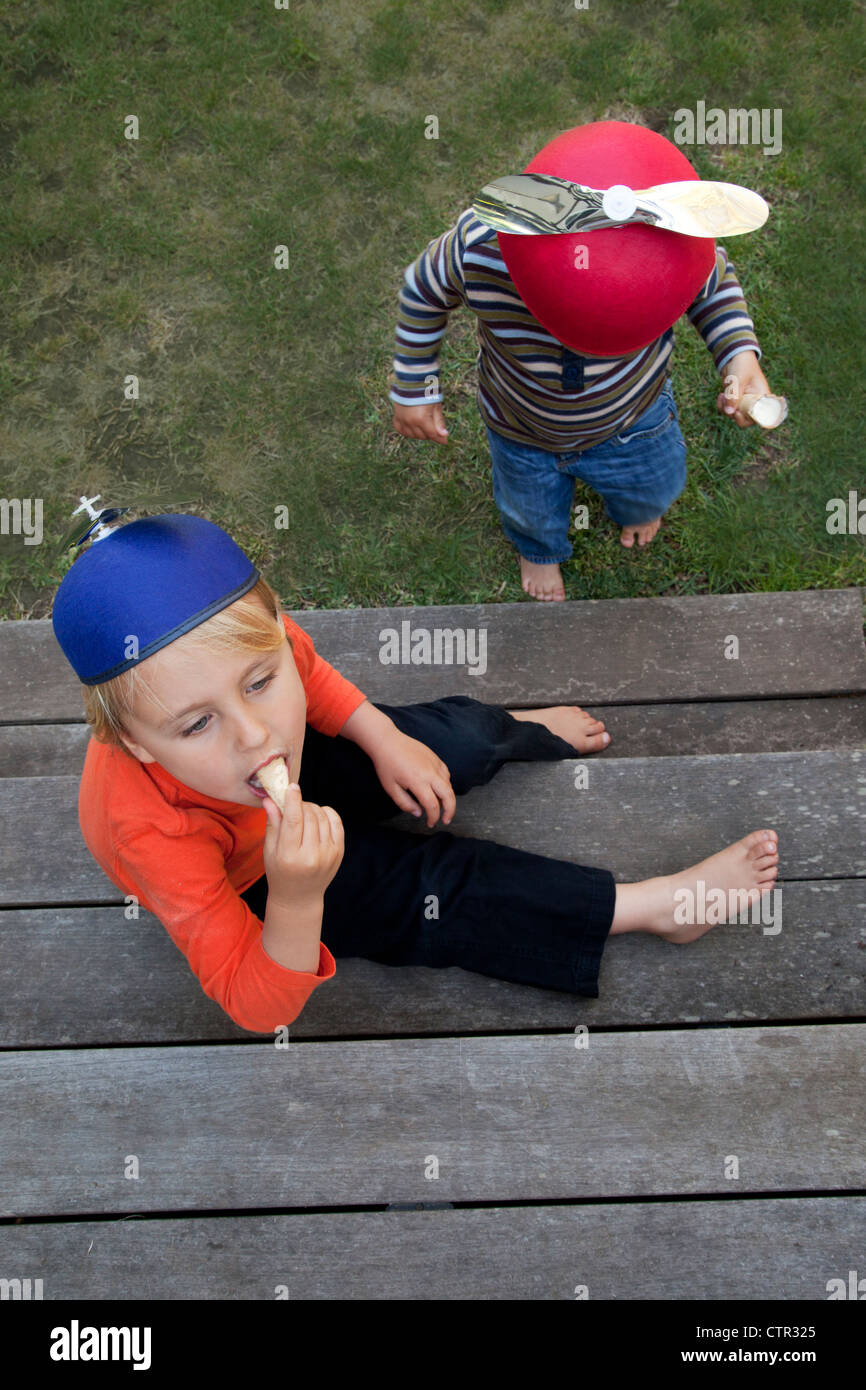 Zwei Brüder sind auf einer Stufe essen Eiscreme-Kegel. Stockfoto