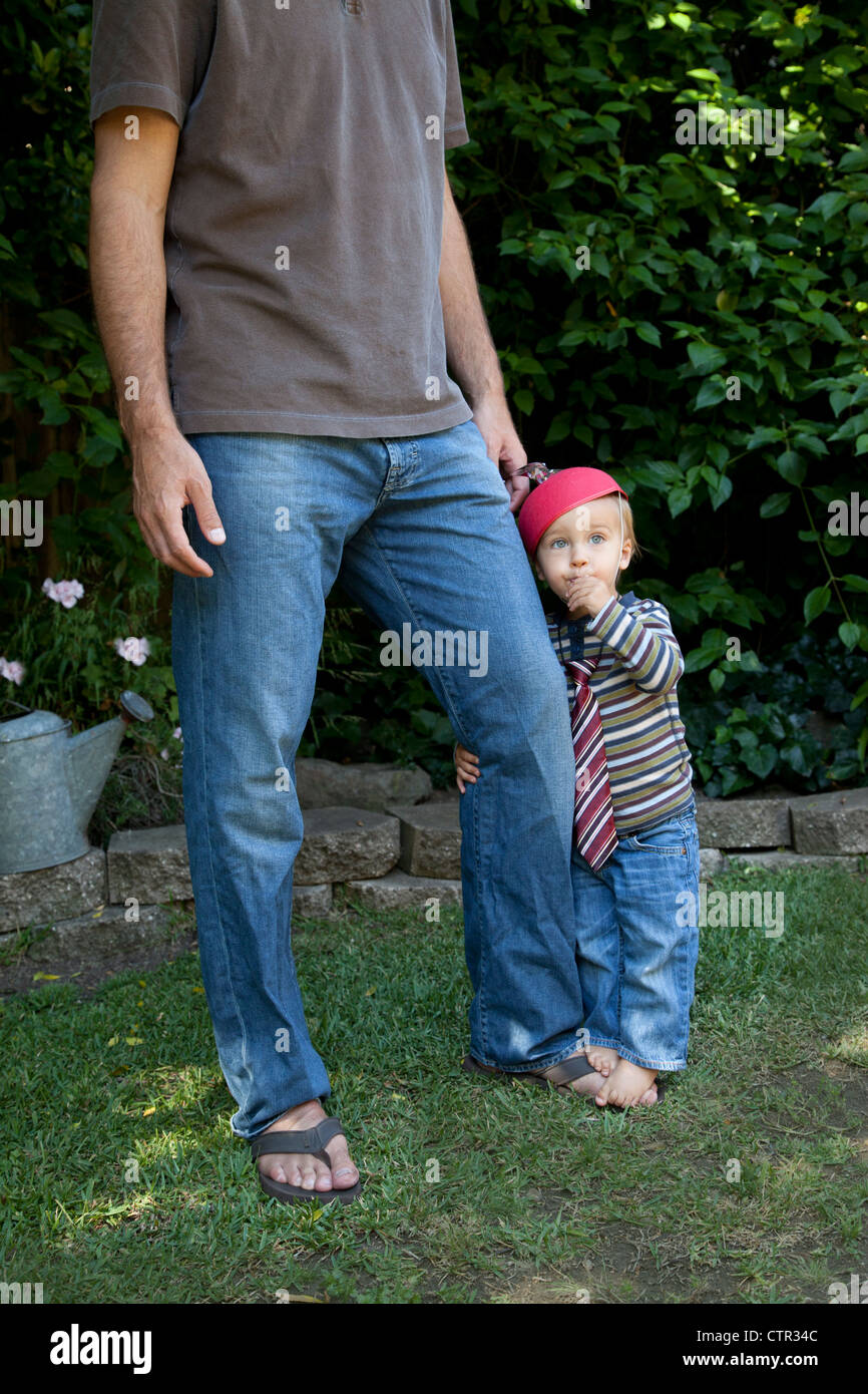 Ein kleiner Junge umarmt seinen Vater Hosenbein. Stockfoto