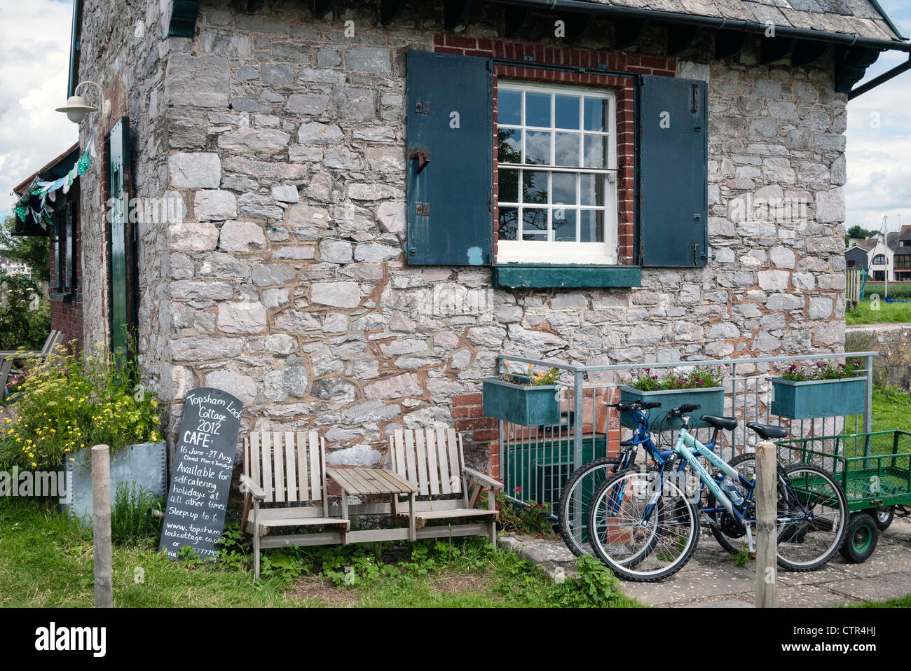 Alte Schleuse des Tierhalters Cottage, Exeter Ship Canal, Fahrräder im Garten, Bath, in der Nähe von Exeter, Devon, England, Großbritannien Stockfoto