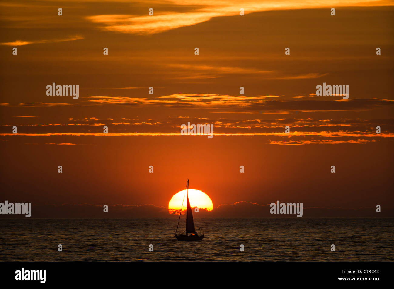 Eine Yacht Segeln über die Einstellung Sonne Aberystwyth Wales UK Sommerabend, wales Cardigan Bay west UK Stockfoto