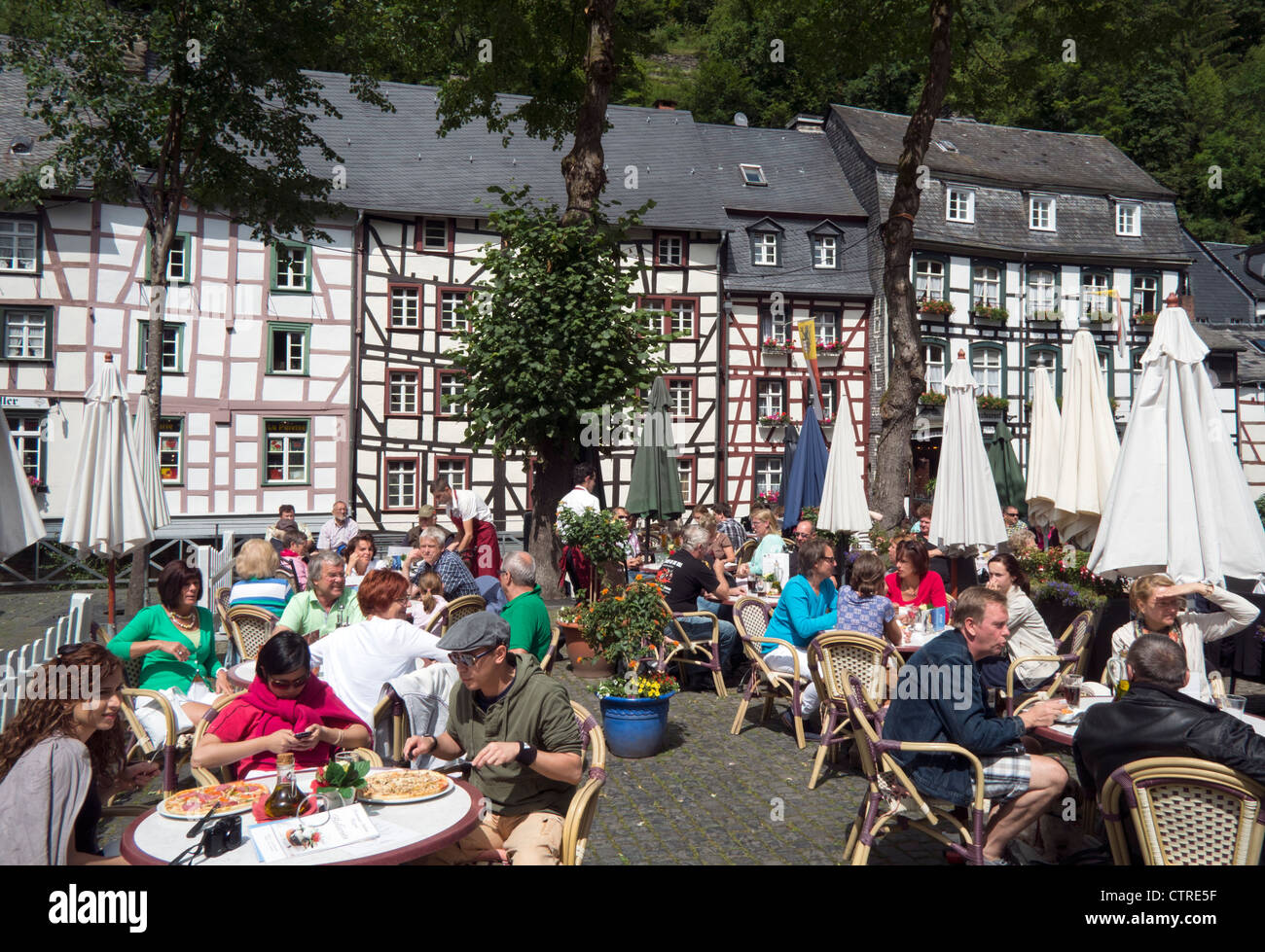 Busy Restaurant im Freien mit Touristen im historischen Dorf von Monschau in der Eifel Region von Deutschland Stockfoto