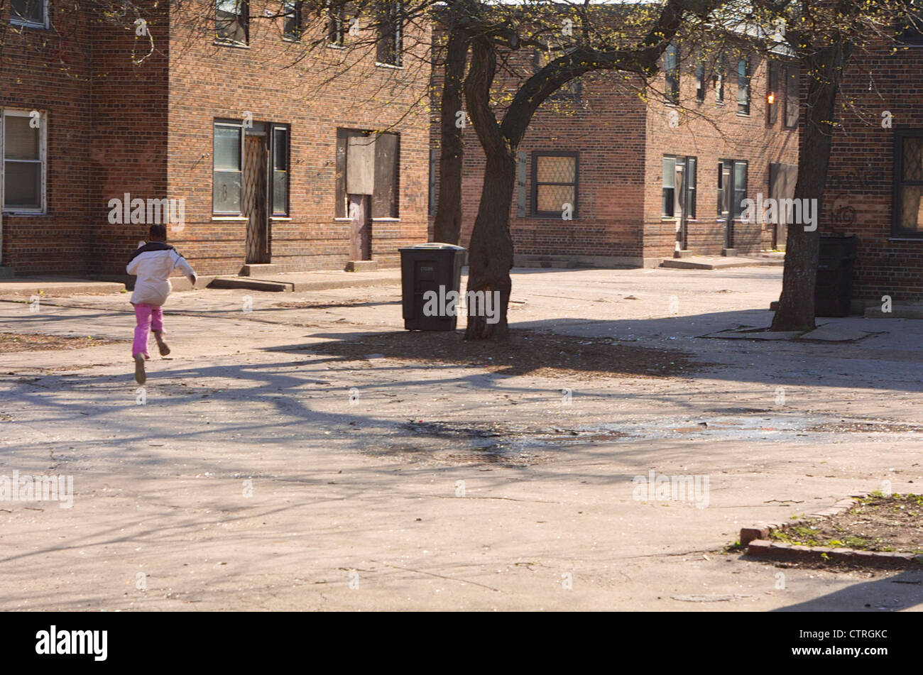 Ein junges Mädchen läuft durch den Verurteilten Ida B. Wells Wohnprojekt in Chicago am 24. April 2002. Stockfoto