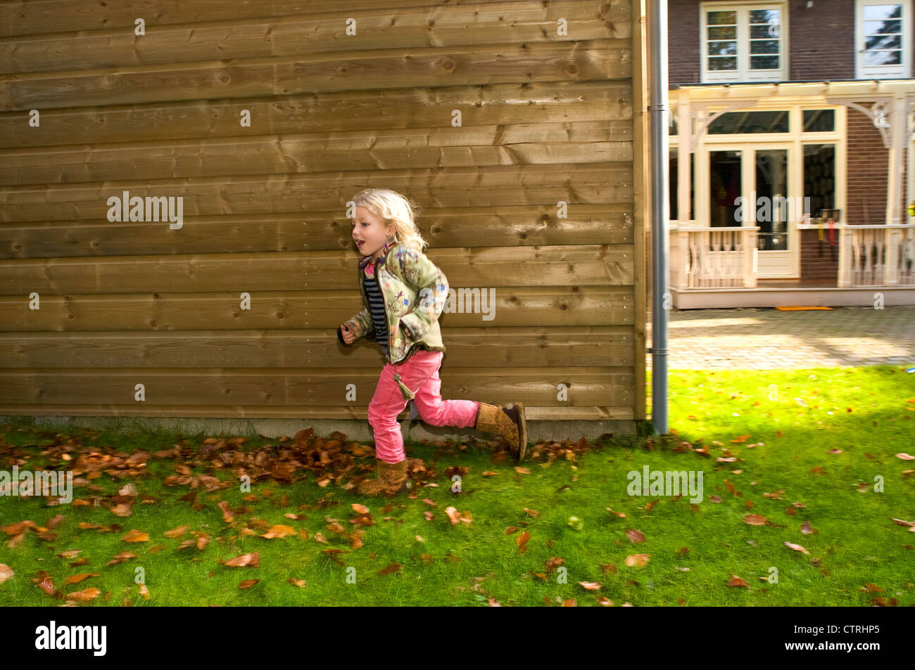 Kleines Mädchen läuft in ihrem Garten Stockfoto